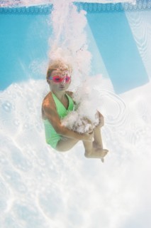 Caucasian girl swimming underwater in pool