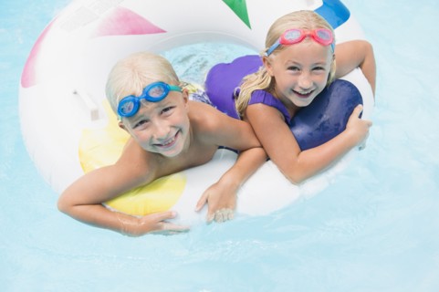 Caucasian children playing in swimming pool