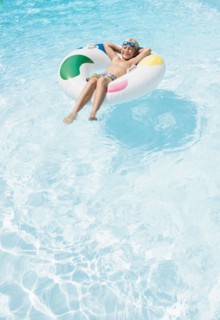 Caucasian boy floating in inflatable ring in swimming pool