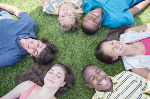 High angle view of teenagers laying on grass lawn