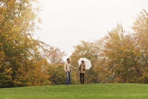 Couple walking with umbrella in park