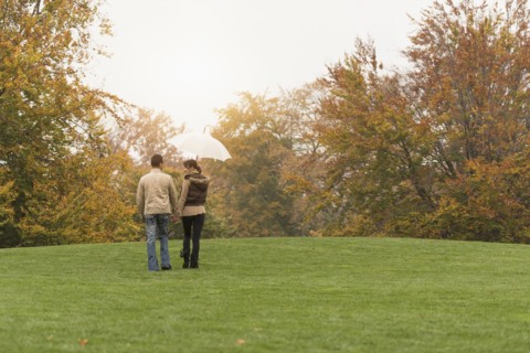 Couple walking with umbrella in park