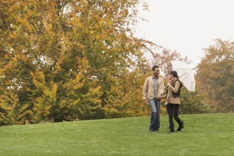 Couple walking with umbrella in park