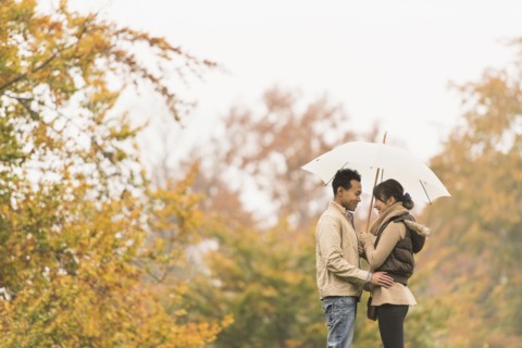 Couple standing with umbrella in park