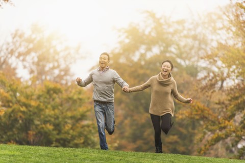 Smiling couple running in park