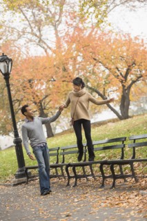 Couple playing on park bench