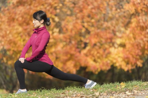 Asian runner stretching in park