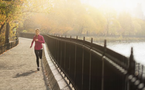 Asian woman running on waterfront path