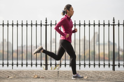 Asian woman running on waterfront path