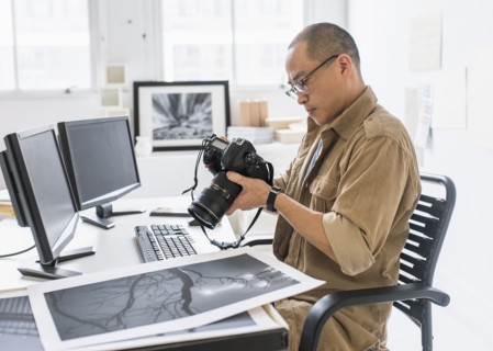 Korean photographer using camera at desk