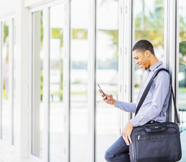 Black businessman using cell phone outdoors