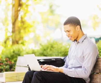 Black businessman using laptop outdoors
