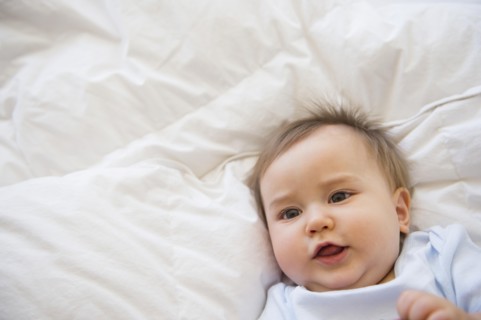 Close up of mixed race baby laying on bed