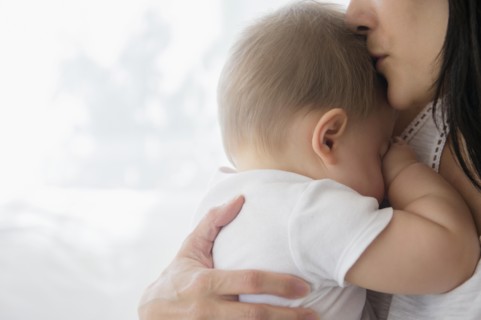 Close up of mixed race mother kissing baby on forehead