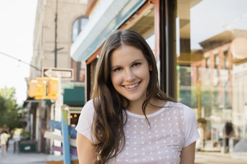 Caucasian woman smiling on urban sidewalk