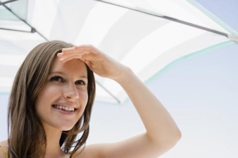 Caucasian woman shielding her eyes from sun