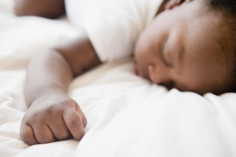 Close up of Black baby boy sleeping on bed