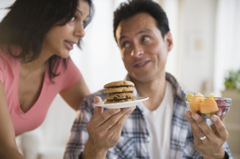 Couple choosing between healthy and unhealthy snacks