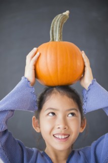 Vietnamese girl balancing pumpkin on head