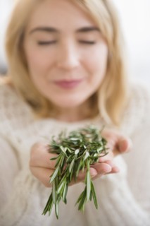 Caucasian woman smelling fresh herbs