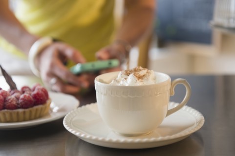 Caucasian woman using cell phone at cafe
