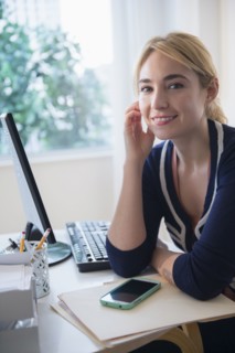 Caucasian businesswoman smiling at desk