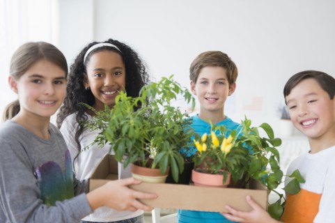 Smiling children holding potted plants