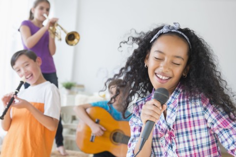 Happy children singing and playing music