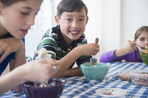 Close up of smiling children eating ice cream sundaes