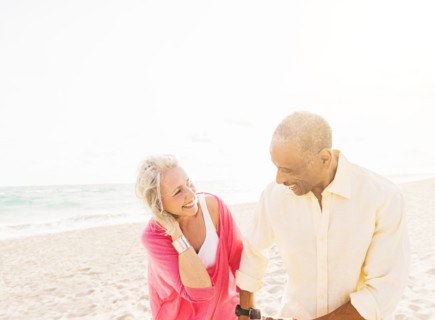 Older couple walking on beach