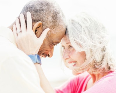 Older couple touching foreheads on beach