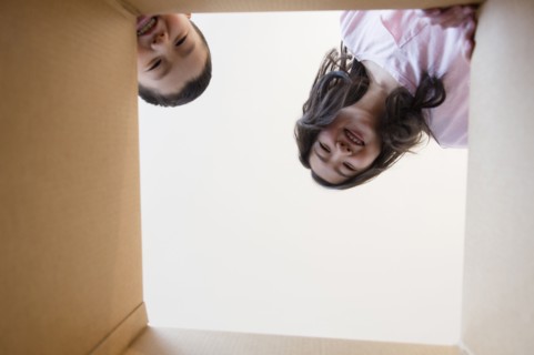 Low angle view of Asian brother and sister opening box