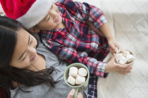 Asian brother and sister drinking hot cocoa at Christmas