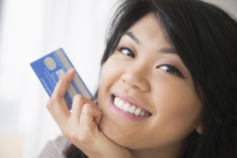 Smiling Pacific Islander woman holding credit card