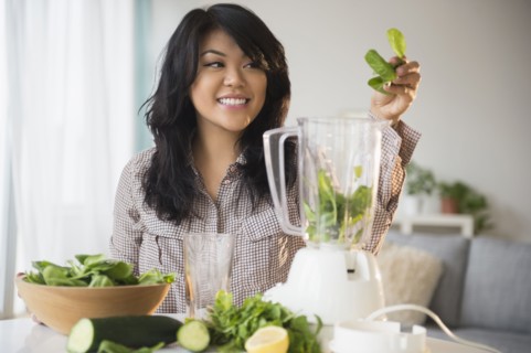 Pacific Islander woman making green smoothie in blender