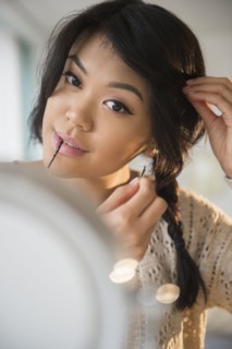 Pacific Islander woman braiding her hair