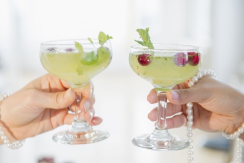 Women toasting with cocktails and pearl necklaces