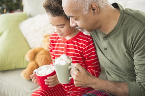 Mixed race grandfather and grandson drinking hot chocolate at Christmas