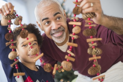 Mixed race grandfather and grandson holding Christmas decorations