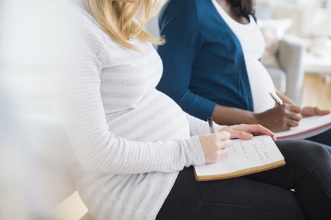 Pregnant women taking notes in class