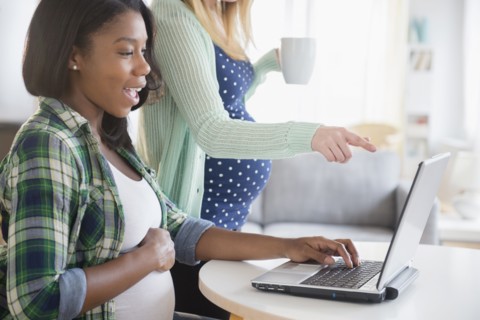 Pregnant women using laptop at table