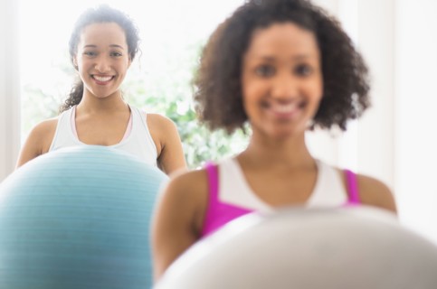 Women working out with fitness balls in exercise class