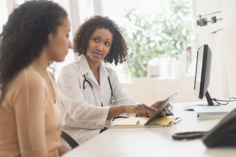 Doctor and patient using digital tablet in office