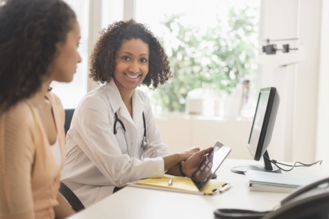 Doctor and patient using digital tablet in office