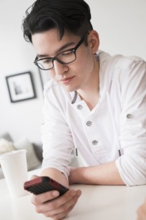 Mixed race man texting on cell phone