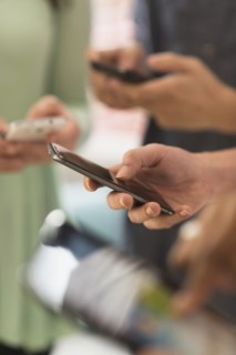 Close up of hands of people texting with cell phones