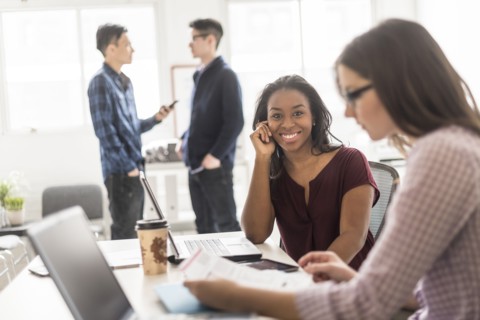 Businesswoman smiling with technology in office