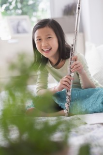 Chinese girl holding flute on bed