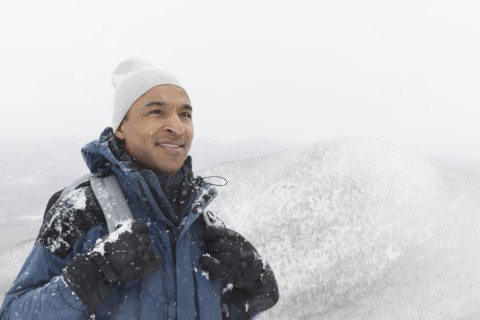 Black man hiking in snow