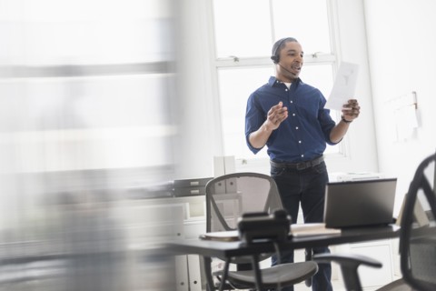Black businessman talking on headset in office
